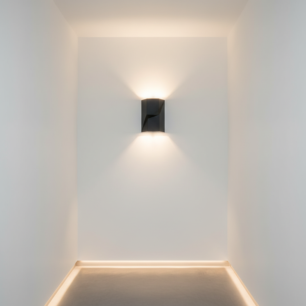 A sleek matte black wall sconce with geometric lines and an integrated LED strip, mounted on a pristine white hallway wall. The sconce emits a soft, even glow upwards and downwards, emphasizing the architectural structure of the hallway without casting harsh shadows. The environment features smooth, uninterrupted surfaces and a clear, organized pathway lined with subtle baseboard lighting. Shot from a slightly elevated angle and framed with a strong vertical axis, the image highlights the sconce as a sculptural accent in a balanced, corporate-inspired modern interior. The overall style is clean, professional, and highly refined, echoing the portfolio’s expertise in structured lighting implementation.